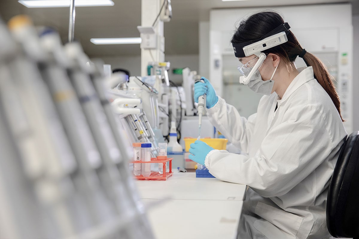 Moziware Cimo Use case - a female lab technician working with chemicals wearing cimo on head