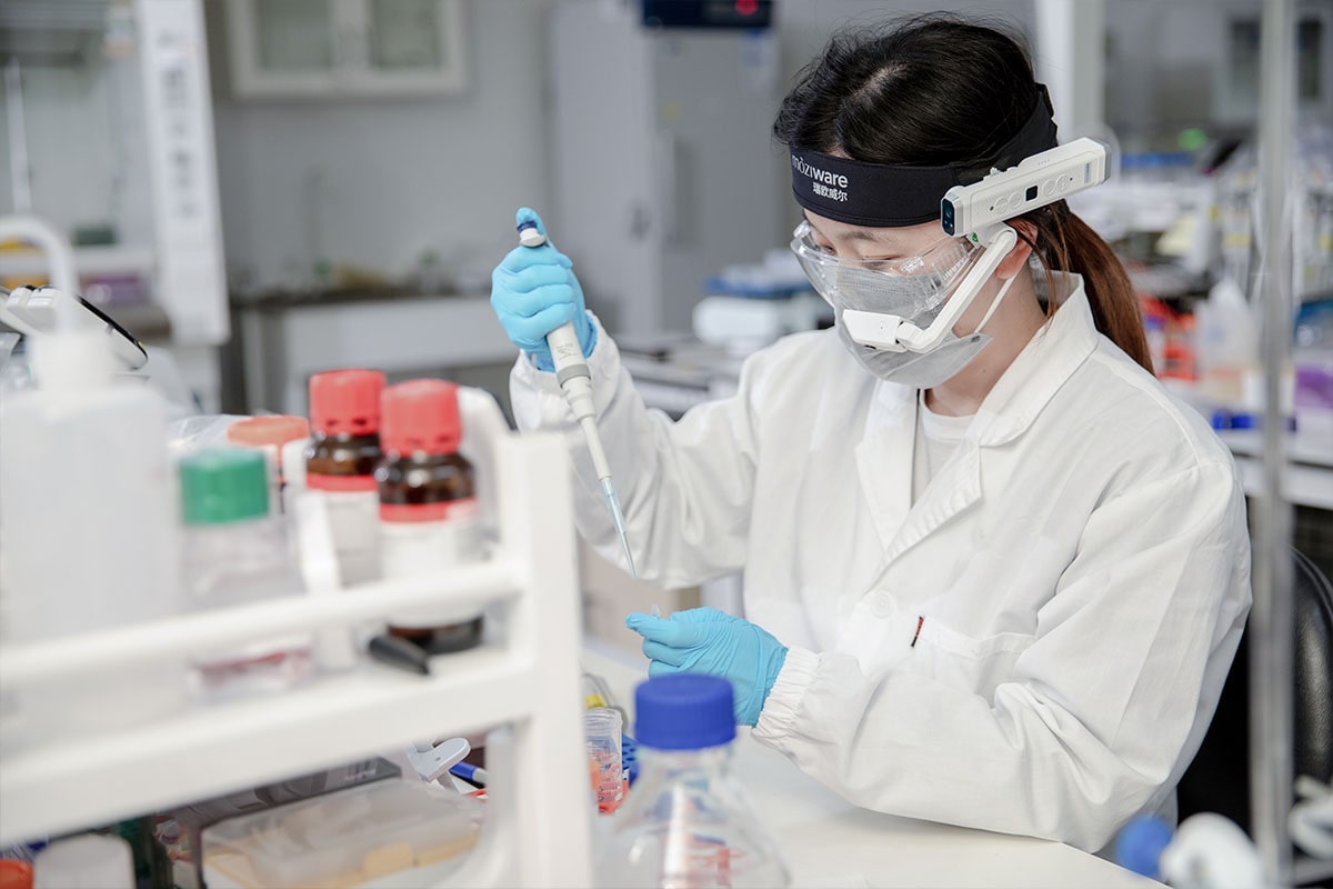 Moziware Cimo Use case - a female lab technician working with chemicals wearing cimo on head