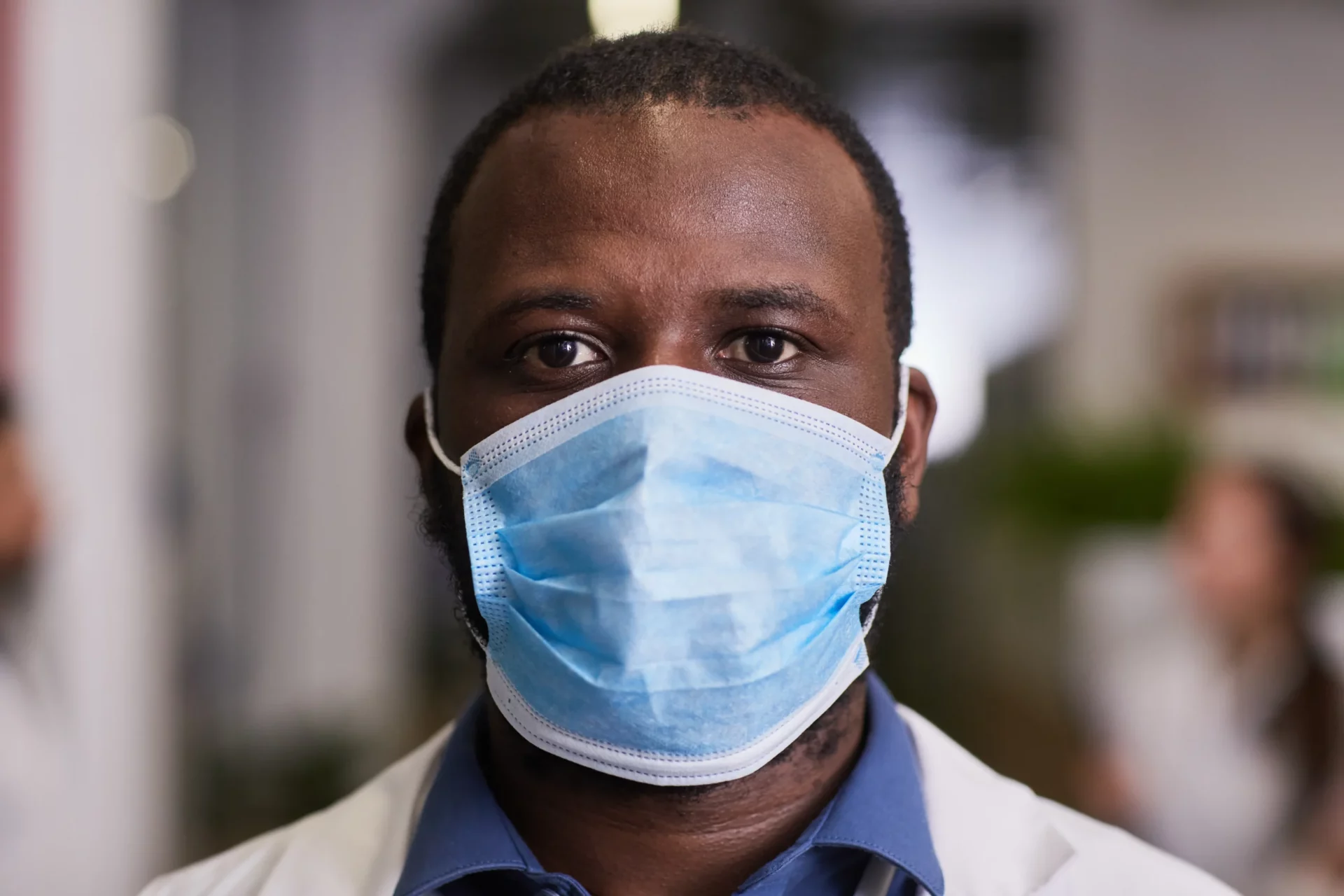A physician standing in the hospital wearing a mask on his face